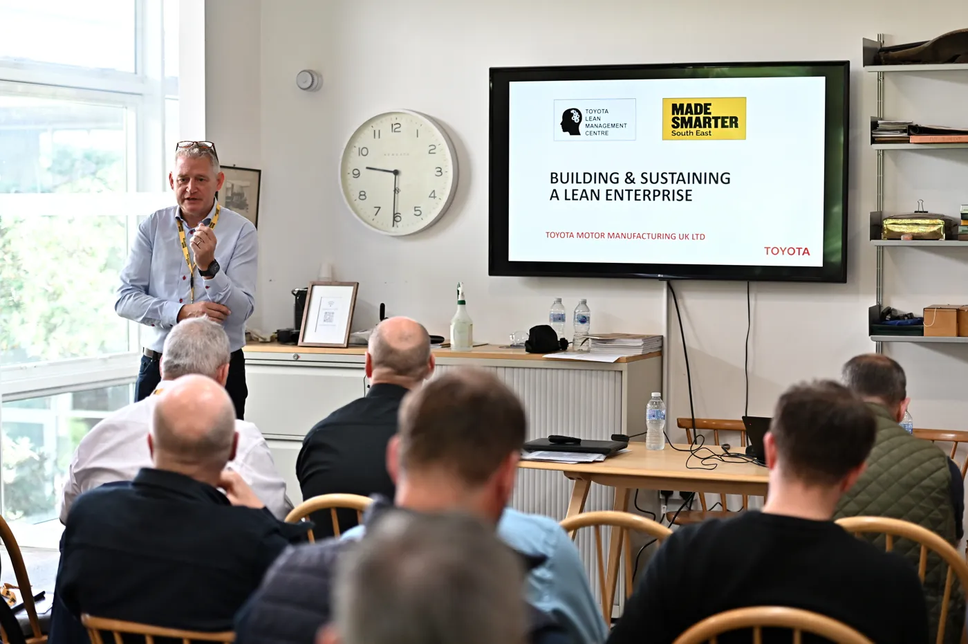 Jez Heys of Made Smarter South East speaks to a seated audience of manufacturers beside a screen reading Building and Sustaining a Lean Enterprise, with the Toyota Lean Management Centre and Made Smarter South East logos.